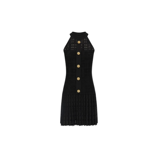 Via Manzoni Boutique black sleeveless knit dress with halter neck, gold buttons, and pleated skirt.