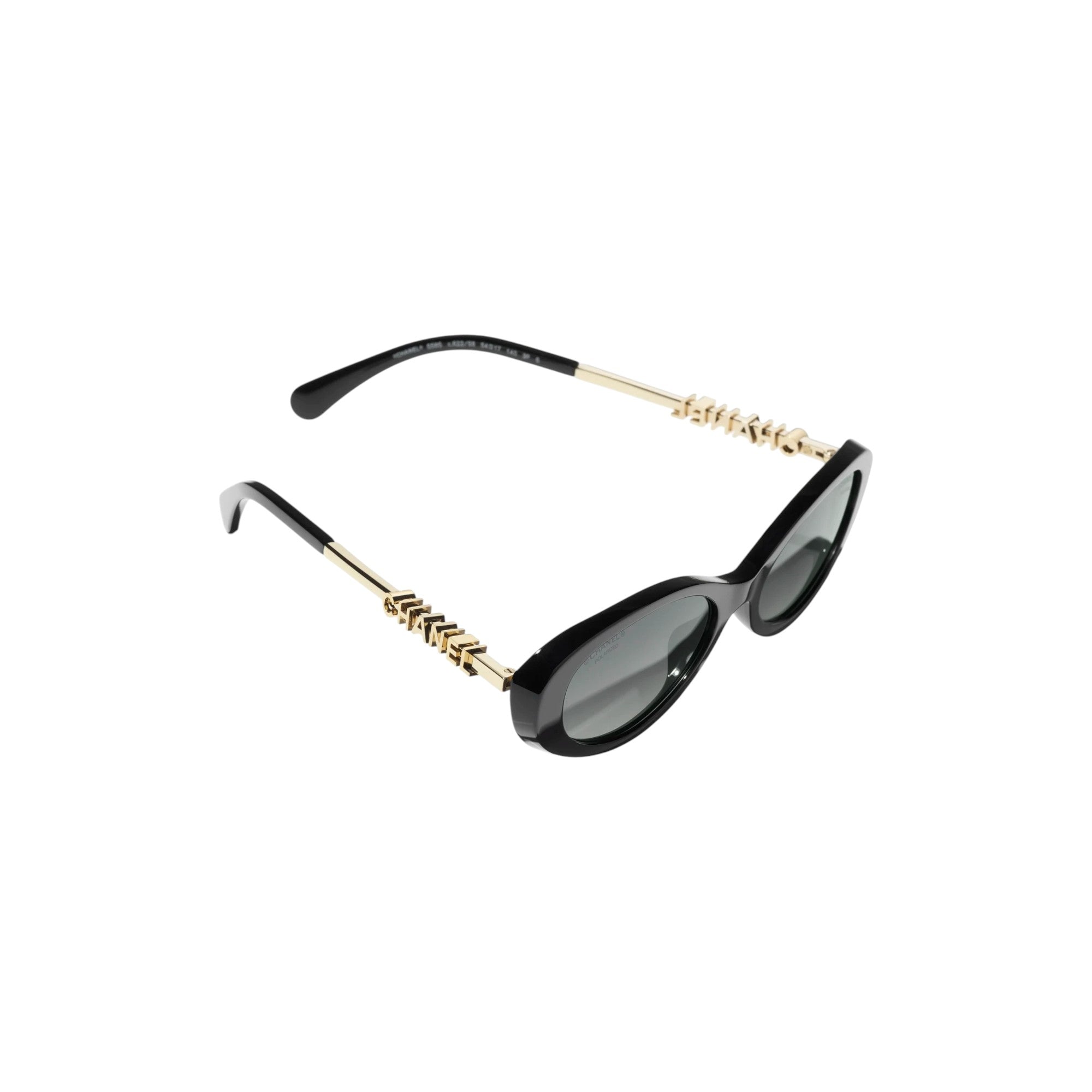 Via Manzoni Boutique Chanel oval sunglasses in black acetate with gold metal temples featuring signature lettering.