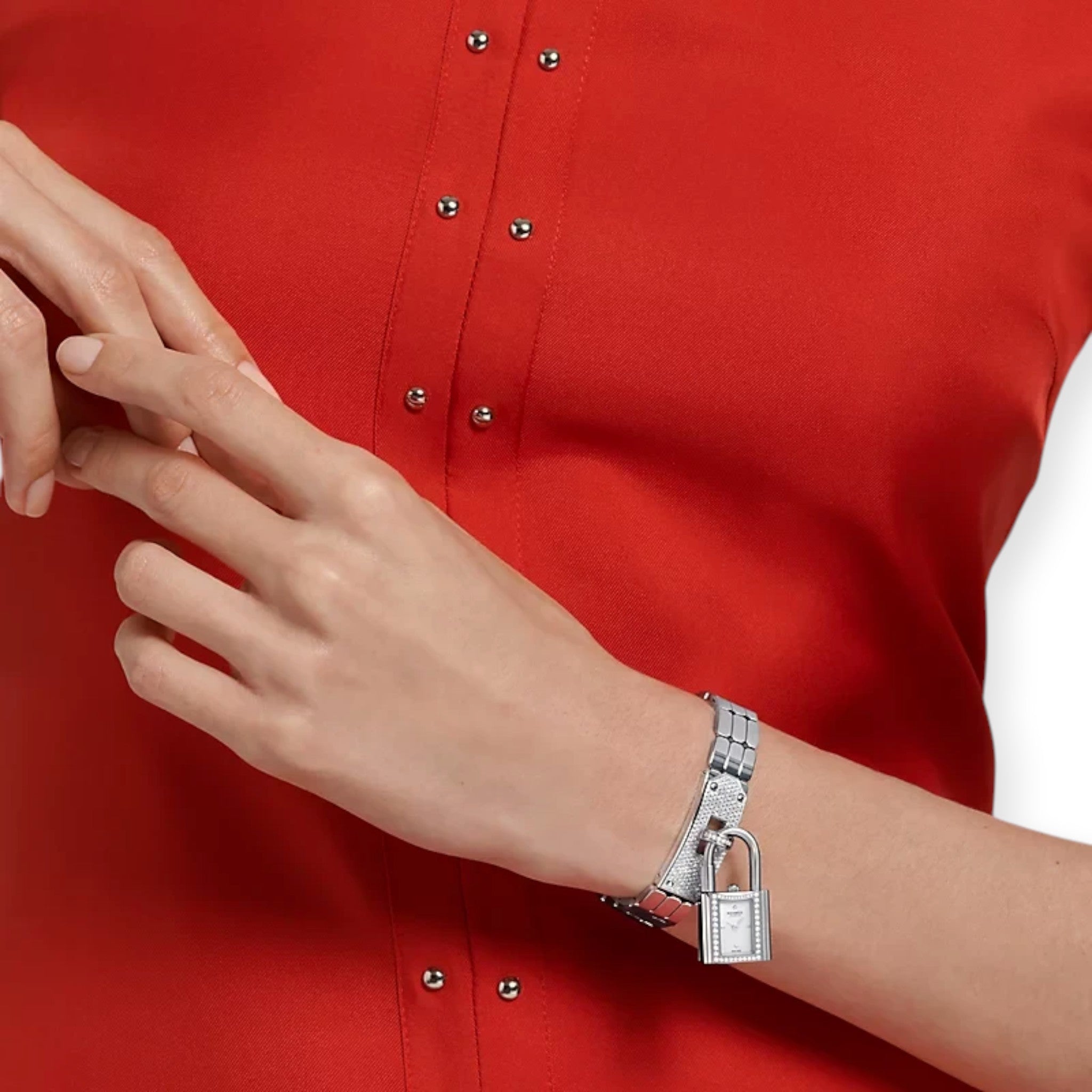 Via Manzoni Boutique Hermès Kelly mini watch in stainless steel with diamond bezel worn on a wrist with a red top