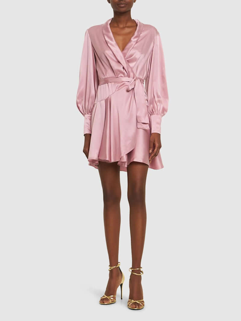 Long-sleeve wrap silk minidress in rose pink with pussy-bow fastening and flared skirt, styled with strappy heels.