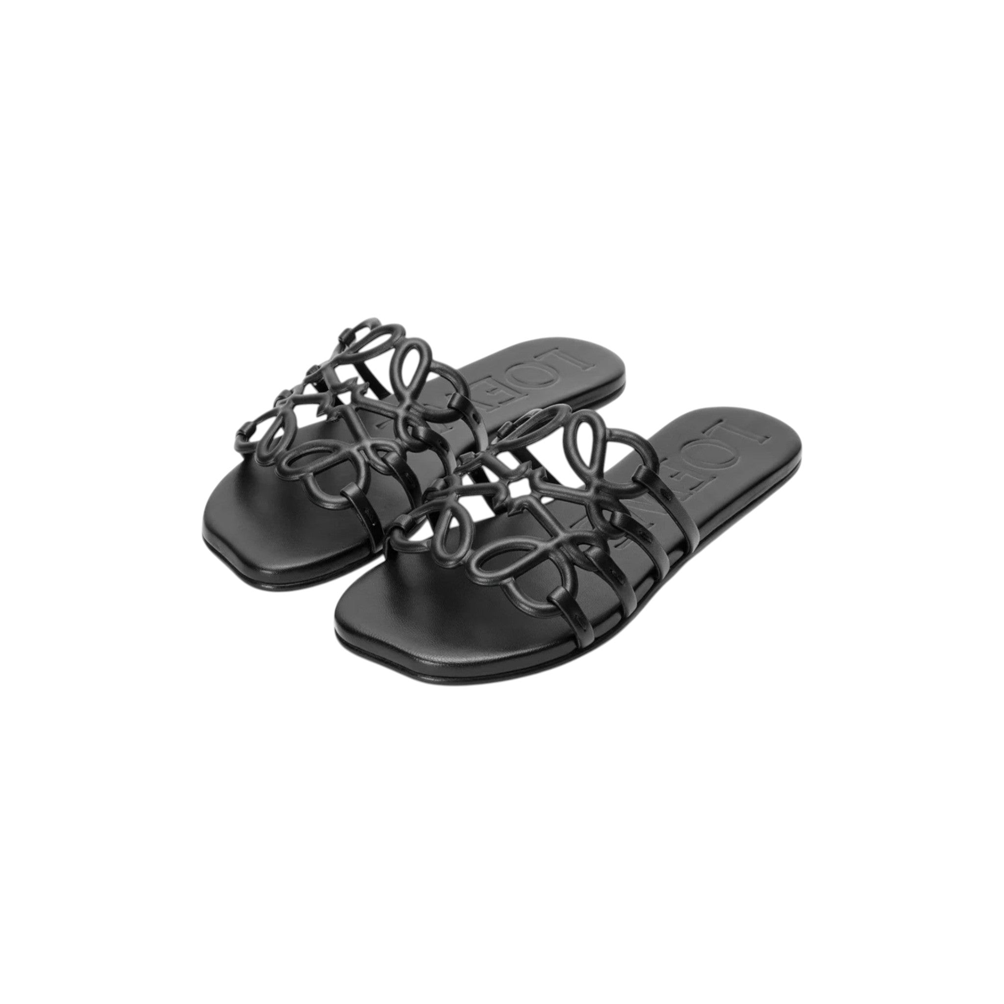 Via Manzoni Boutique black leather slide sandals featuring an intricate knotted Anagram motif strap and flat silhouette.